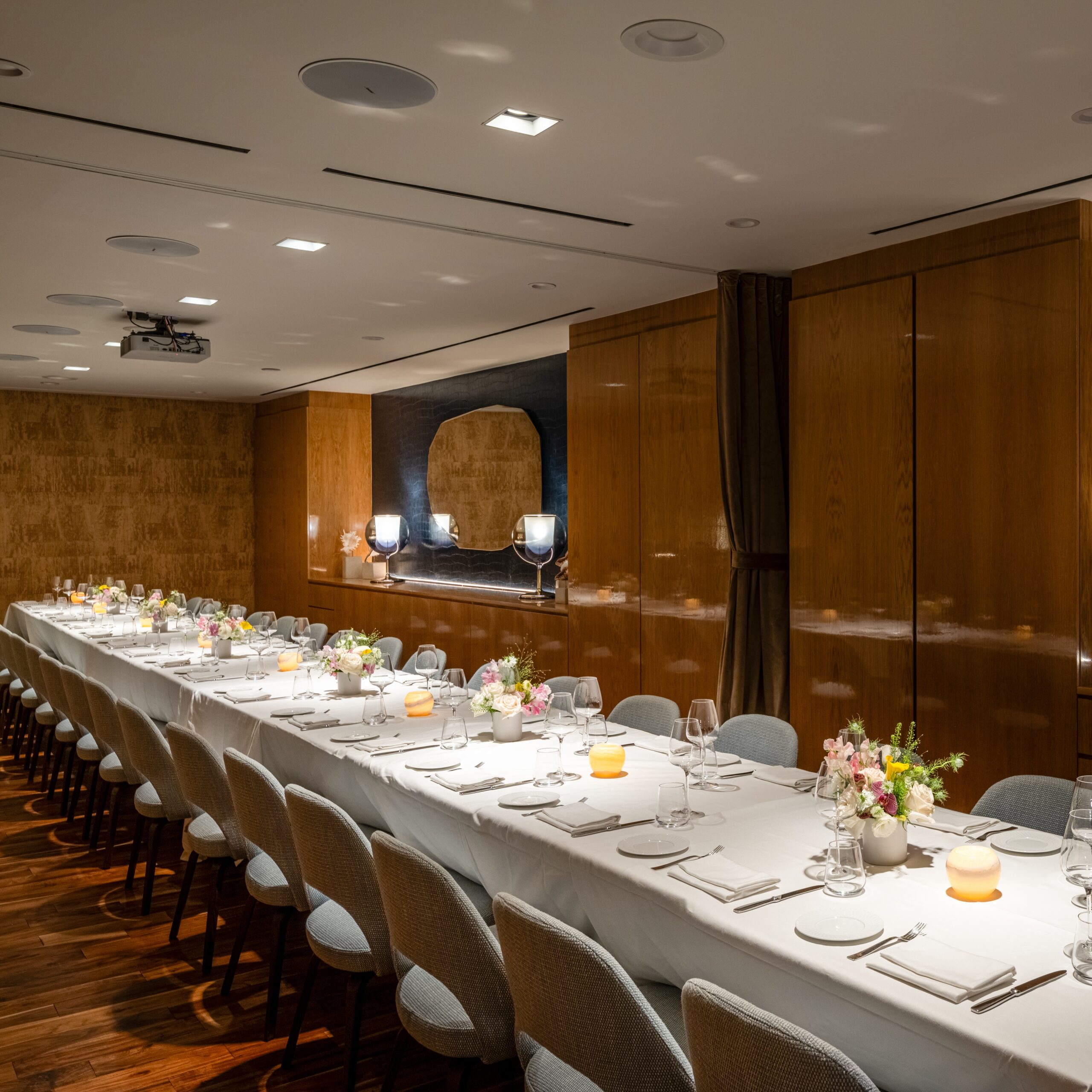 marea beverly hills private dining room - a cool lit space with a long table covered with a white tablecloth, and textured brown walls